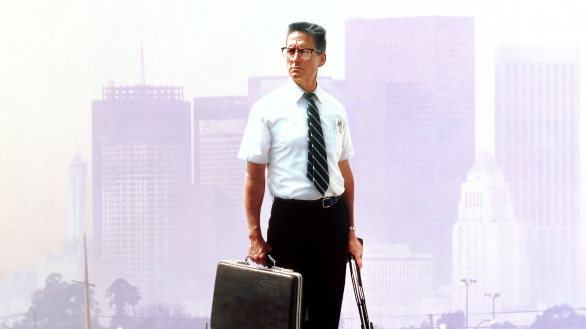 Michael Douglas as William "D-Fens" Foster in the movie Falling Down, with close cropped hair, wearing a white shirt and glasses.